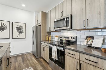 A modern kitchen with wooden cabinets and stainless steel appliances.